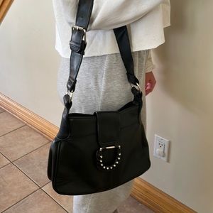 Black leather bag/purse with detail flap closure and zippered inside pocket.